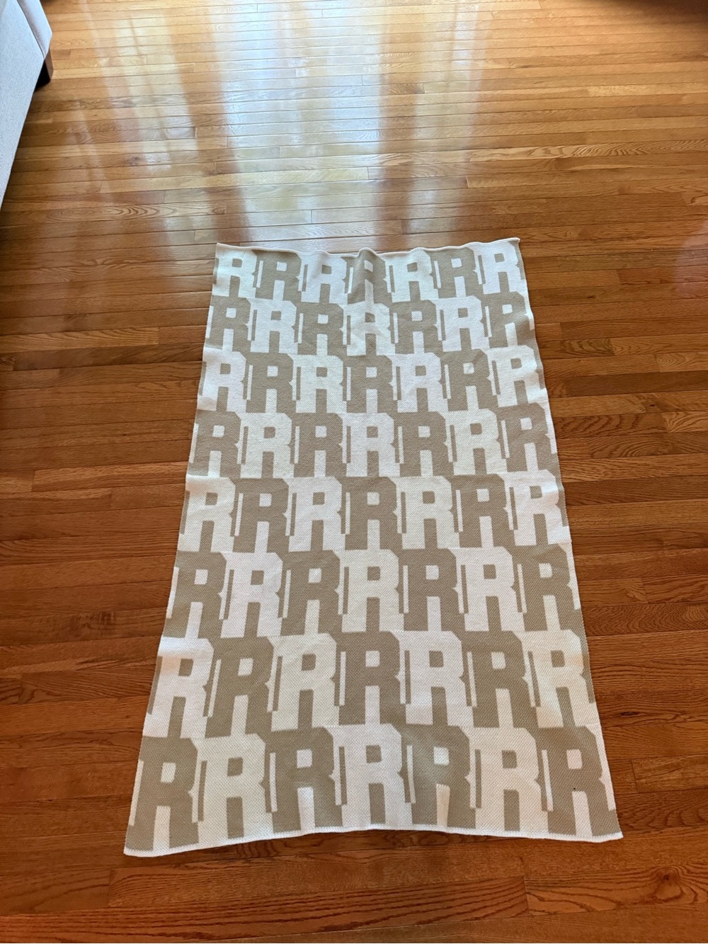 BaubleBar Beige and White “R” initial throw blanket